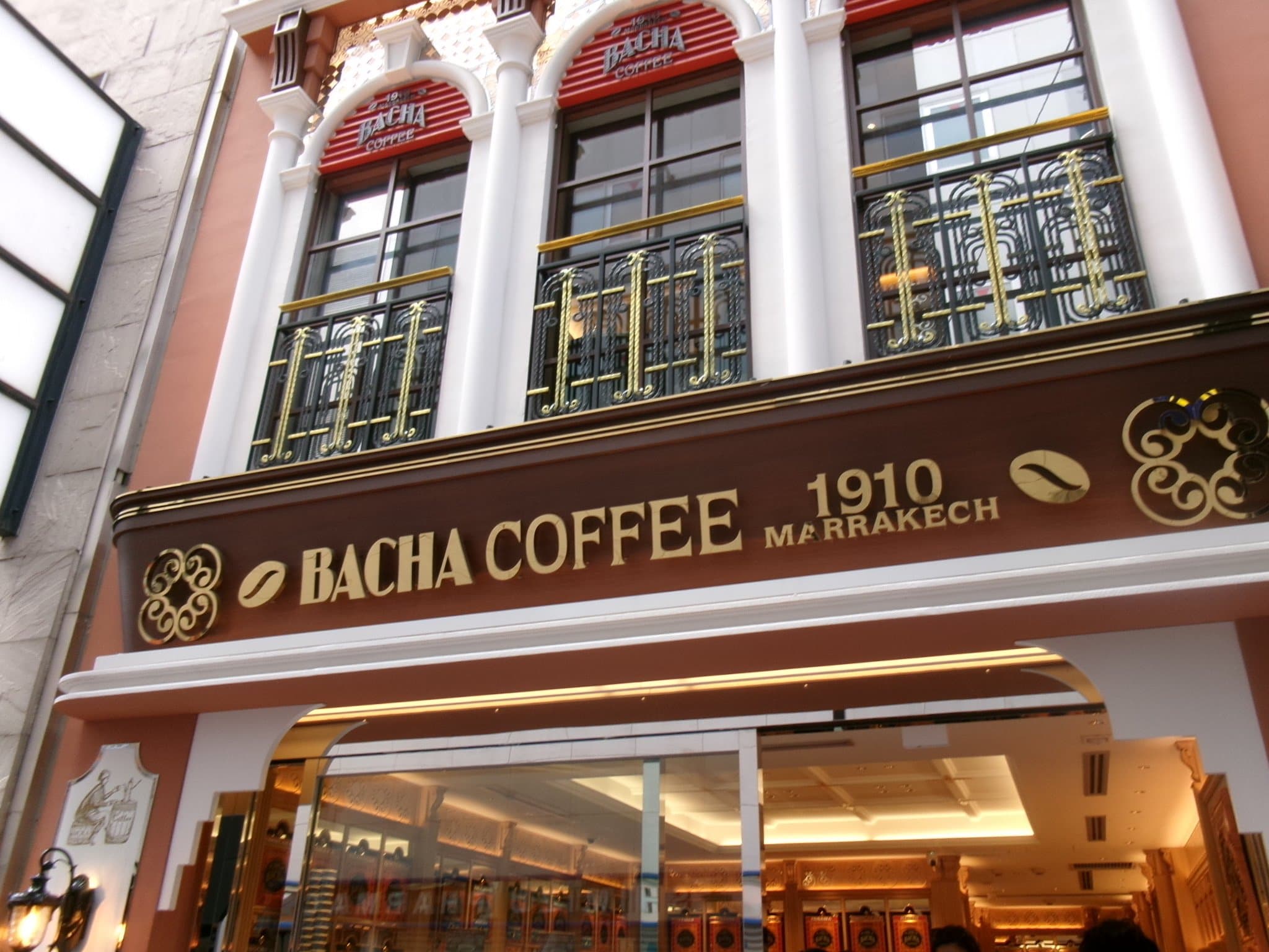 Bacha Coffee 銀座的店面外觀 - 粉橘色外牆與金色招牌 1910 MARRAKECH