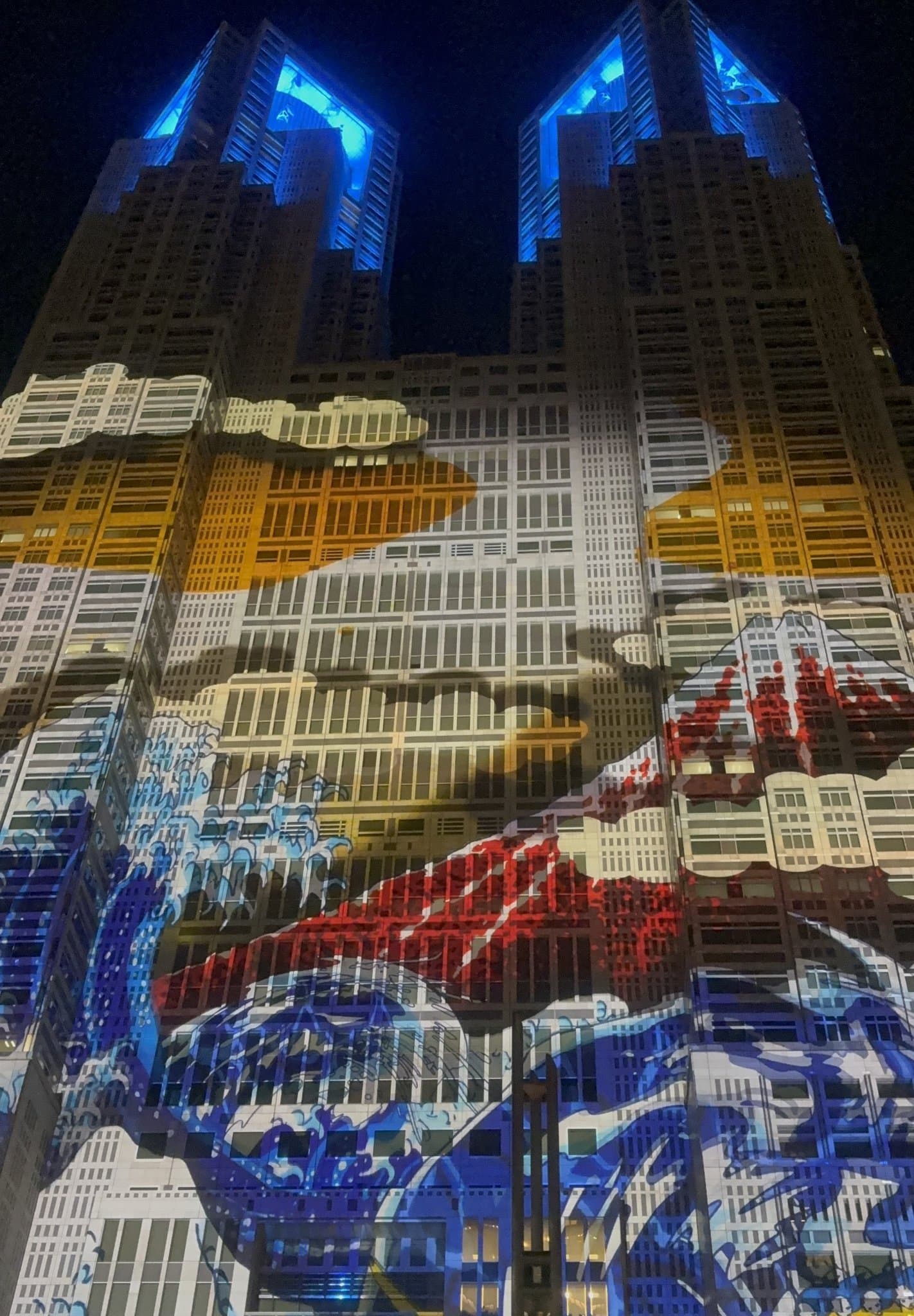 東京都廳光雕投影 - 浮世繪風格的大浪與紅色富士山,雙塔頂端打上藍光